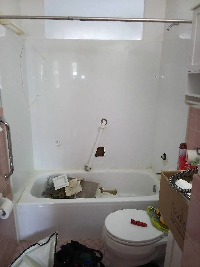 The original tub alcove, with a cracked and stained one-piece fiberglass surround
