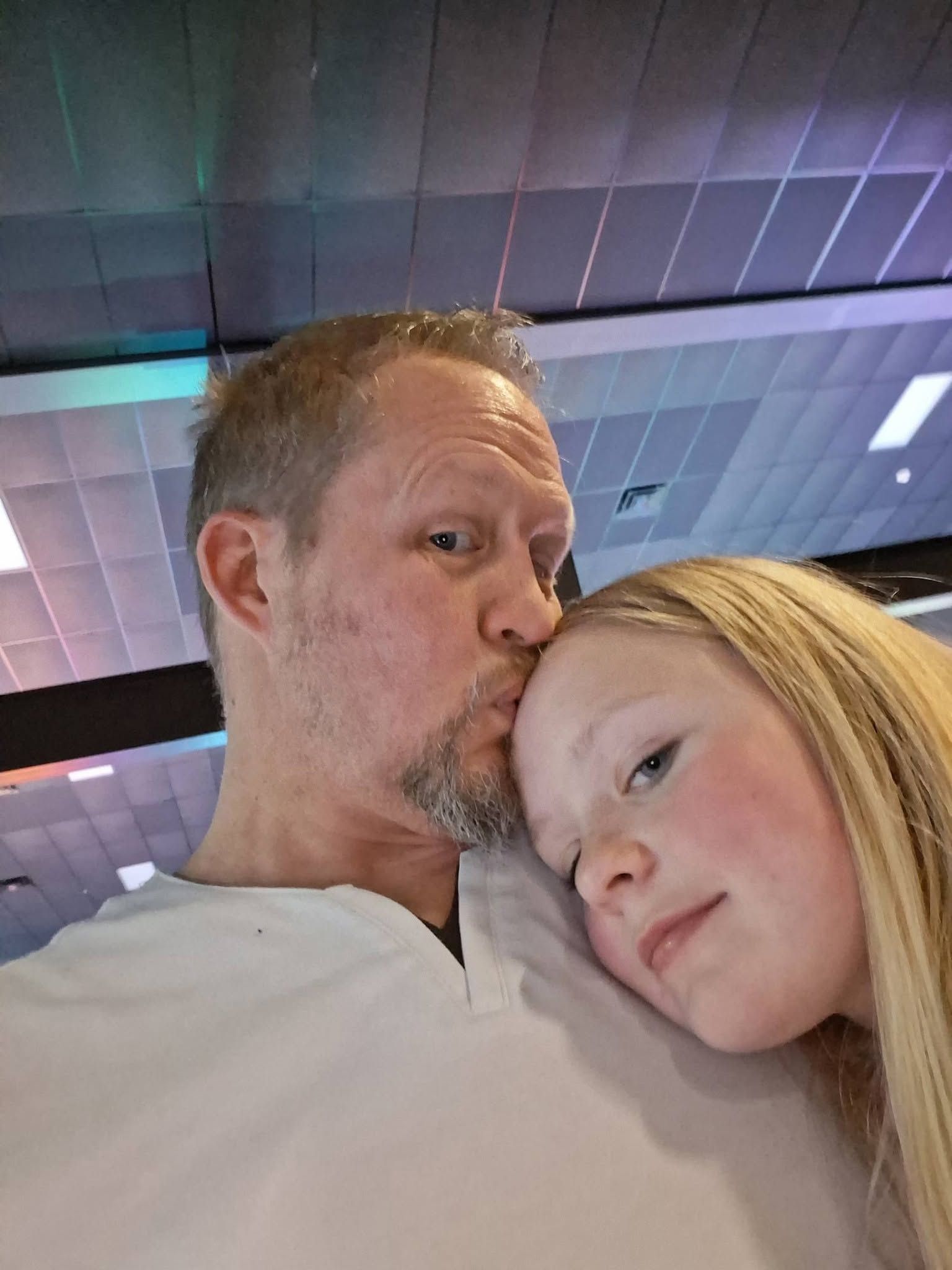 Matt kissing his daughter on the forehead